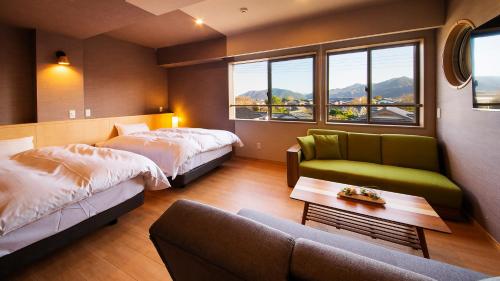 um quarto de hotel com duas camas e um sofá em 宵待ちの宿　萩一輪 em Hagi