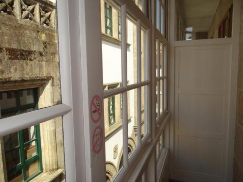 a hallway with windows and a door at Pensión O Códice by Moradas Nieto in Santiago de Compostela