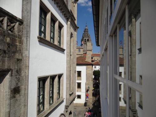 an alley in the city with the cathedral in the background at Pensión O Códice by Moradas Nieto in Santiago de Compostela