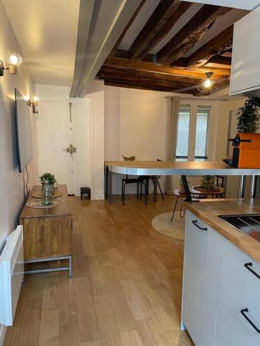 une cuisine avec des armoires blanches et une table dans une pièce dans l'établissement Lovely apartment Central, Le Marais, Paris, à Paris