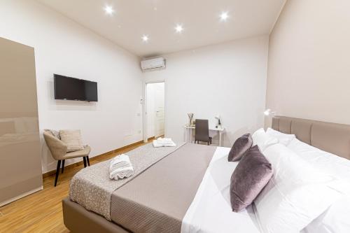 um quarto com uma cama grande e uma TV de tela plana em White Gold em Nápoles
