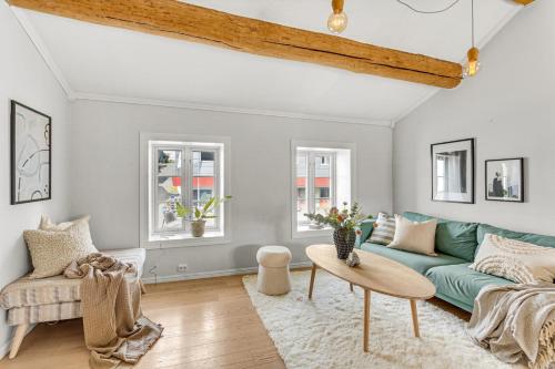 un soggiorno con divano verde e tavolo di Arctic Homes - Historic Tromsø a Tromsø