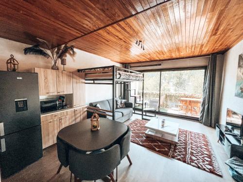 a kitchen and living room with a table and a refrigerator at Grand Studio « Ô Soleil » 4 pers. 200m des pistes. in La Salle Les Alpes