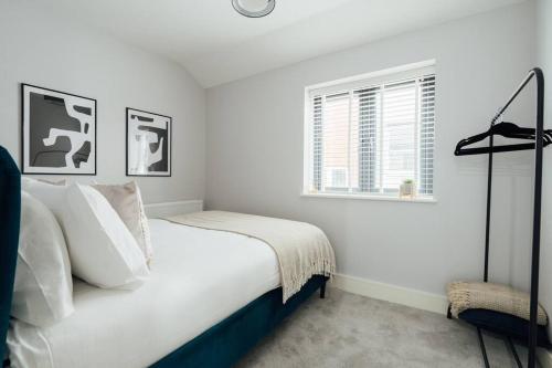 Inviting 2 Bedroom House in Dorking في دوركينغ: غرفة نوم بيضاء بها سرير ونافذة