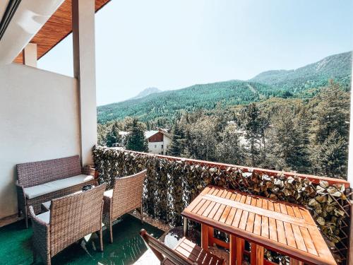 d'un balcon avec une table, des chaises et des montagnes. dans l'établissement Grand Studio « Ô Soleil » 4 pers. 200m des pistes., à La Salle Les Alpes