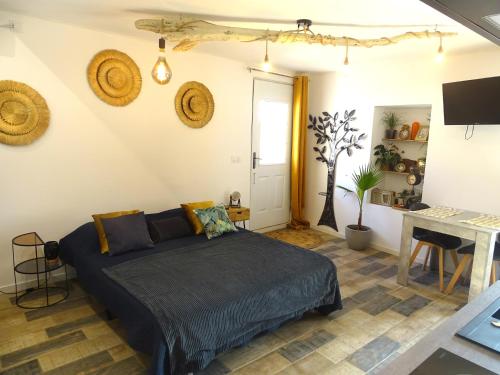 ein Schlafzimmer mit einem Bett in einem Zimmer mit einem Tisch in der Unterkunft Studio 2 personnes à Moussan in Moussan