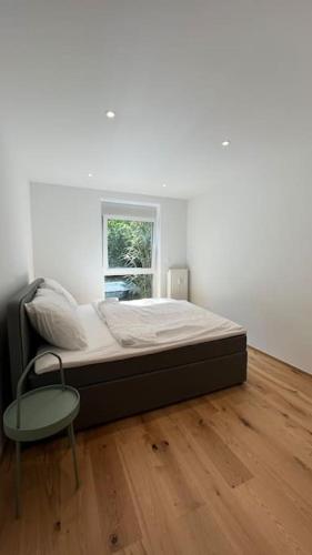 a bedroom with a bed and a table and a window at Gartenwohnung neben dem LKH in Graz