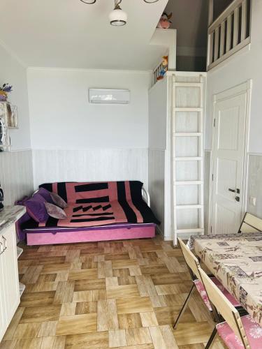a bedroom with a bed and a wooden floor at Flower Breeze in Chebanka