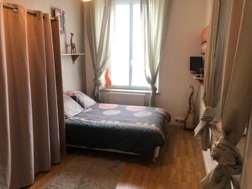 mała sypialnia z łóżkiem przed oknem w obiekcie Chez Jo w mieście Flize