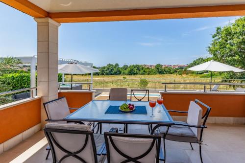 a patio with a table and chairs on a balcony at Villas Lotus with Pool and Jacuzzi in Pula