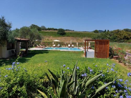 a yard with a swimming pool and flowers at Panmar in Vasilikos