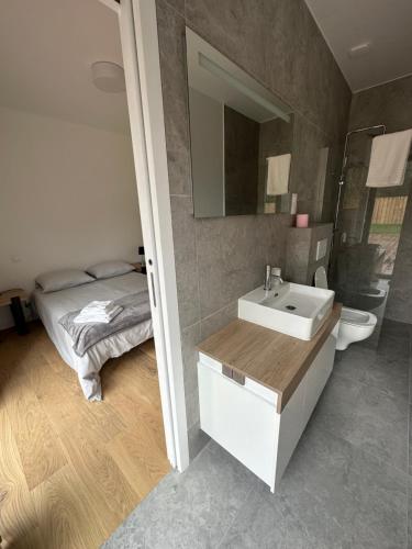 ein Bad mit einem Waschbecken und einem Bett in der Unterkunft Maison Villa à proximité du zoo de Thoiry in Arnouville-lès-Mantes