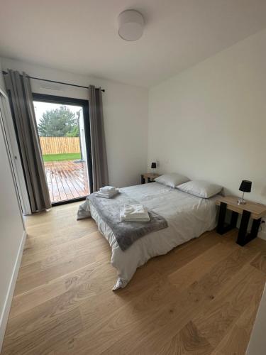 ein Schlafzimmer mit einem Bett und einem großen Fenster in der Unterkunft Maison Villa à proximité du zoo de Thoiry in Arnouville-lès-Mantes