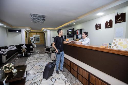 a man standing at a bar in a hotel lobby at Hotel Tigran Mets Yerevan in Yerevan