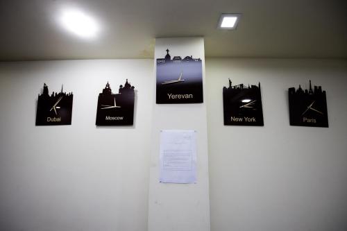 a wall with four clocks on a wall at Hotel Tigran Mets Yerevan in Yerevan