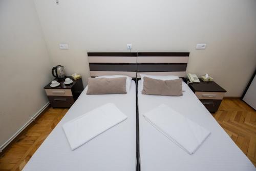 a bedroom with a large white bed with two pillows at Hotel Tigran Mets Yerevan in Yerevan
