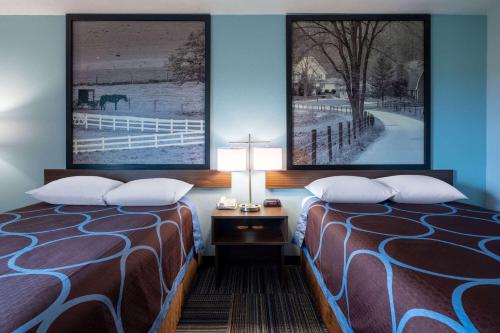 a hotel room with two beds and a table with a lamp at Super 8 by Wyndham Mattoon in Mattoon