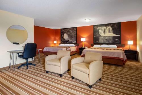 a hotel room with two beds and two chairs at Super 8 by Wyndham Mattoon in Mattoon