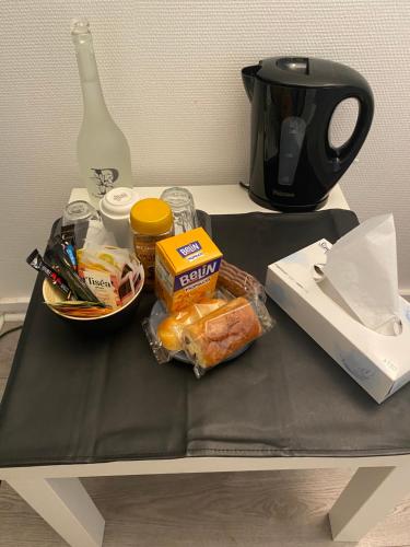 - une table avec de la nourriture au-dessus d'une table avec une cafetière dans l'établissement Cosy room chez l'habitant, à Montigny-le-Bretonneux