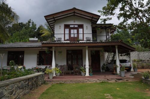 a house with a balcony on top of it at Nature valley homestay in Ella