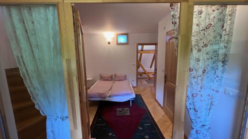 a small room with a small bed in a room at Complexul Turistic Căsuțele din grădină: Căsuța cu Stuf in Marga