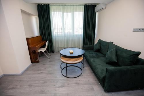 a living room with a green couch and a table at Hotel Tigran Mets Yerevan in Yerevan
