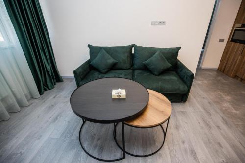 a living room with a green couch and a table at Hotel Tigran Mets Yerevan in Yerevan