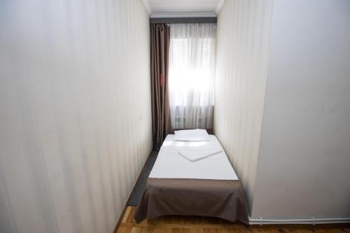 a small bed in a room with a window at Hotel Tigran Mets Yerevan in Yerevan