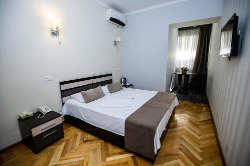 a bedroom with a large bed and a wooden floor at Hotel Tigran Mets Yerevan in Yerevan