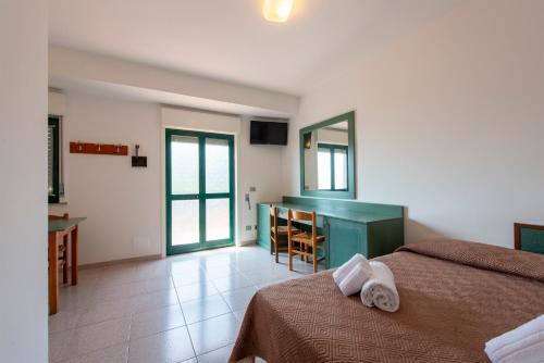 a bedroom with a bed and a table and a desk at Villaggio Alkantara in Giardini Naxos