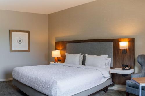 a hotel room with a large bed and a chair at Hampton Inn & Suites Boerne in Boerne