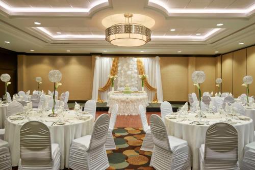 a banquet hall with white tables and chairs and a chandelier at Hilton Garden Inn Toronto Airport West/Mississauga in Mississauga