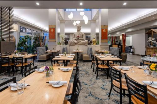 a restaurant with tables and a statue in the background at Hilton Garden Inn Lenox Pittsfield in Pittsfield
