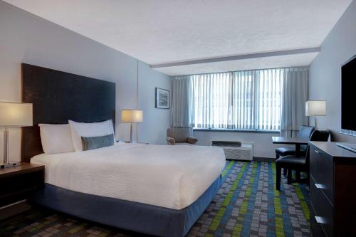 a hotel room with a large bed and a desk at Days Inn by Wyndham Victoria Airport Sidney in Sidney