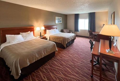 Habitación de hotel con 2 camas y escritorio en Quality Inn & Suites Grants - I-40 en Grants