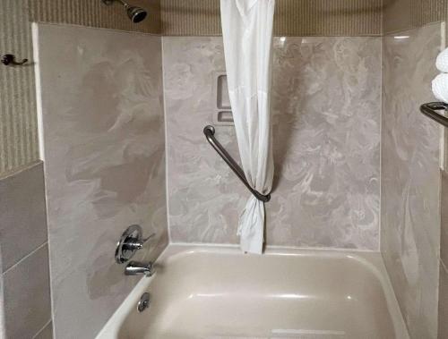 El baño incluye bañera blanca con cortina de ducha. en Quality Inn & Suites Grants - I-40, en Grants