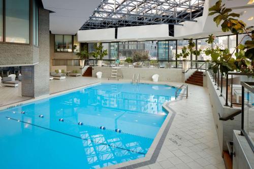 - une grande piscine d'eau bleue dans un bâtiment dans l'établissement DoubleTree By Hilton Montreal, à Montréal