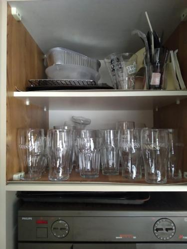 a collection of glasses sitting on shelves in a kitchen at Popasul Dacilor in Predeluţ