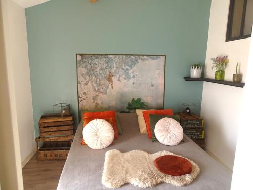 una cama con almohadas coloridas en una habitación en Gites à Moussan ,Domaine de la barque à 5 mins de Narbonne, en Moussan