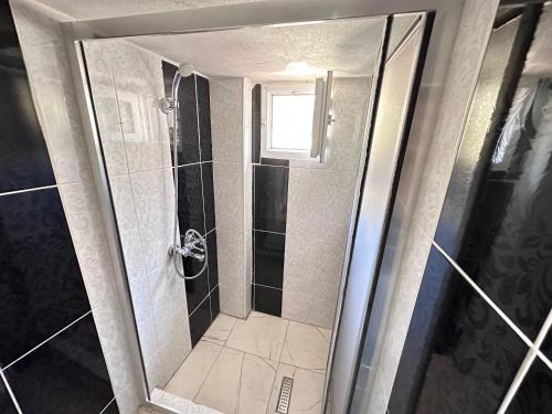 La salle de bains est pourvue d'une douche avec une porte en verre. dans l'établissement STONE HOME Hostel, à Istanbul