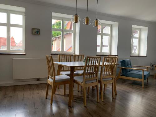 a dining room with a table and chairs and windows at Zum Binnenschiffer Tangermünde in Tangermünde