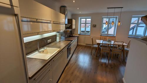 a kitchen with a sink and a dining room with a table at Zum Binnenschiffer Tangermünde in Tangermünde