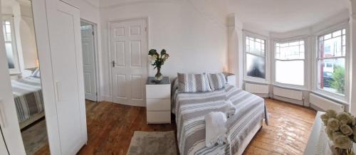 a living room with a couch in a room with windows at Peaceful well equipped flat near central London in London