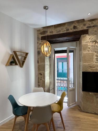 ein Esszimmer mit einem Tisch und Stühlen sowie einem TV in der Unterkunft Apartamento en el Casco Viejo in Bilbao