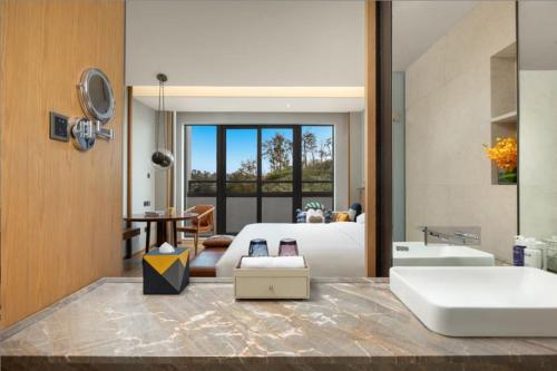 a bathroom with a sink and a living room at voco Thousand Island Lake, an IHG Hotel in Chun'an