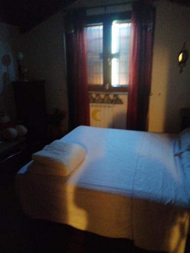 uma cama num quarto escuro com uma janela em Antoine em Marco Simone