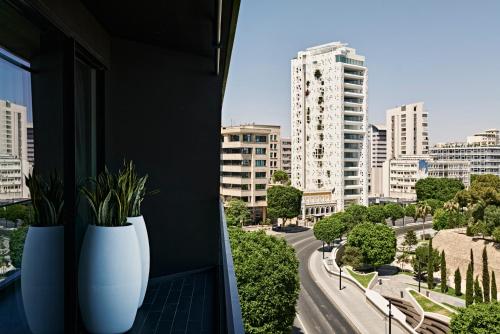 two white vases sitting on a window sill with a city at MAP Boutique Hotel in Nicosia