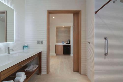 a white bathroom with a sink and a shower at Hilton Garden Inn La Romana in La Romana