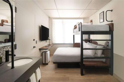 a bedroom with a bunk bed and a bathroom at Motto By Hilton New York City Times Square in New York
