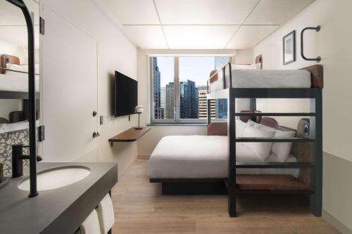 a hotel room with a bunk bed and a bathroom at Motto By Hilton New York City Times Square in New York